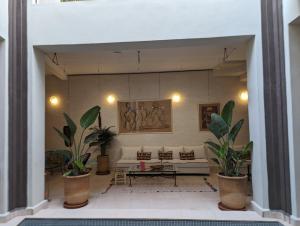 a living room with a couch and some plants at Dar d'Art in Marrakesh