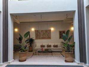 een woonkamer met een bank en een aantal planten bij Dar d'Art in Marrakesh
