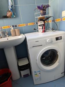 ein Badezimmer mit einer Waschmaschine und einem Waschbecken in der Unterkunft Scanderbeg Square Apartment in Tirana