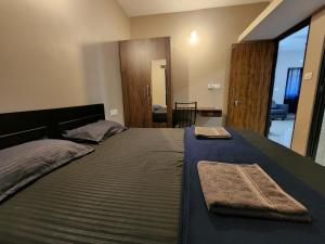 a bedroom with a large bed with two towels on it at 002 MŸKA at Dsouza Heritage, Moira in Mapusa