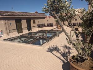 een patio met een zwembad in een huis met een boom bij Dar d'Art in Marrakesh