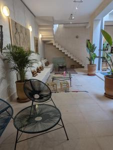 une grande chambre avec des chaises et des plantes en pot dans l'établissement Dar d'Art, à Marrakech