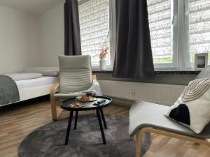 ein Wohnzimmer mit einem Stuhl und einem Tisch in der Unterkunft Schöne Eigentumswohnung in Kassel in Kassel