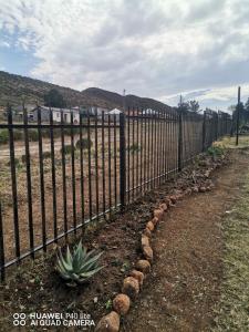 una cerca frente a un patio con una piña en Cacadu Country And Retreat Stay en Lady Frere