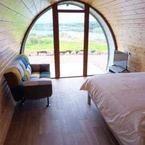 una camera con letto, divano e finestra di Wheelhousepods glamping a Donegal