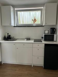 eine weiße Küche mit einem Waschbecken und einem Fenster in der Unterkunft Schöne Eigentumswohnung in Kassel in Kassel