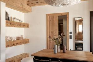 een eetkamer met een houten tafel en een spiegel bij Appartement Rémy - at the foot of the slopes in Saint-Gervais-les-Bains