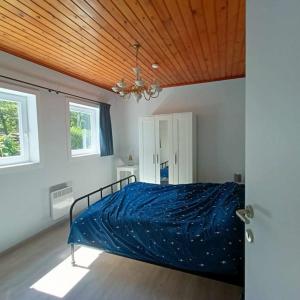 ein Schlafzimmer mit einem Bett mit einer blauen Bettdecke in der Unterkunft Hartedrie vakantiewoning aan zee in De Haan