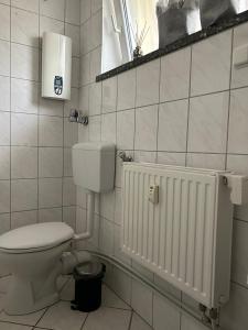 ein weißes Bad mit einem WC und einem Heizkörper in der Unterkunft Schöne Eigentumswohnung in Kassel in Kassel