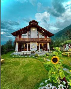 a large building in the middle of a green field at Amarys Boutique Stays Manali in Manāli