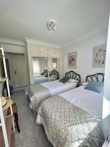 une chambre avec trois lits dans une chambre dans l'établissement 2 linea de playa con piscina, jardín, terraza y parking, à Benidorm