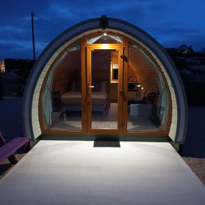 a dome house with a glass door at night at Wheelhousepods glamping in Donegal