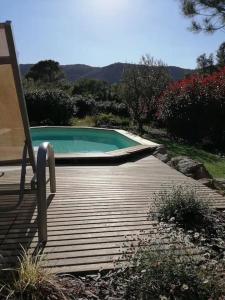 - une piscine avec une chaise sur une terrasse en bois dans l'établissement Gîte de charme avec piscine privative, à Bagnols-en-Forêt