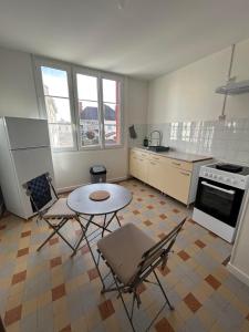 a kitchen with a table and chairs in a room at Appartement centre d Arcis in Arcis-sur-Aube