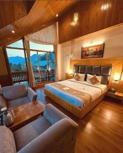 a bedroom with a bed and two chairs in it at Amarys Boutique Stays Manali in Manāli