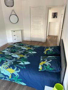 a bedroom with a bed with a blue comforter at Appartement centre d Arcis in Arcis-sur-Aube