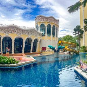 une piscine devant un immeuble avec un toboggan aquatique dans l'établissement Espana Condo Resort Pattaya Pool Access, à Jomtien Beach