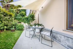 a patio with chairs and a table in a backyard at In riva al mare in Cagliari