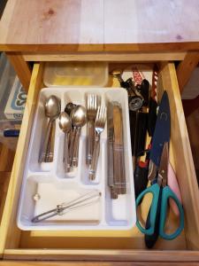 a drawer filled with utensils in a cabinet at Acorn Cottage at Hocking Vacations in Logan