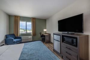 una camera d'albergo con una grande TV a schermo piatto di Wingate by Wyndham Butte City Center a Butte