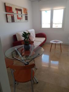 un soggiorno con un divano e un tavolo di vetro di REYNURBAN a Castillo de Sabinillas Altre 5 foto