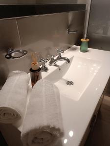 Departamento Elena 2 في سانتا روزا: مغسلة الحمام بيضاء وعليها منشفتين