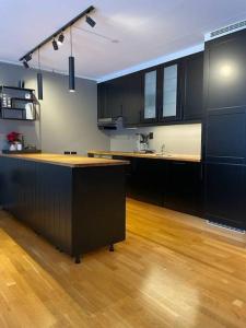 a kitchen with black cabinets and a wooden floor at Leilighet i Oppdal - 4 soverom, 2 stuer og 2 bad in Oppdal