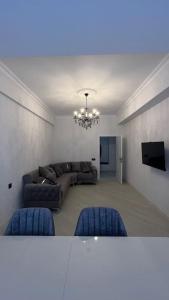 uma sala de estar com um sofá e uma televisão em Spacious Rooms em Baku