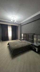 um quarto com uma cama grande e uma janela em Spacious Rooms em Baku