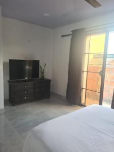 um quarto com uma cama e uma televisão numa cómoda em CasaSpa em La Dorada