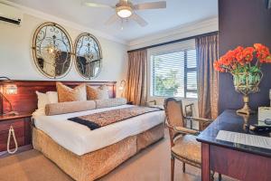 een slaapkamer met een bed, een bureau en een raam bij Amber Guest Lodge in Knysna