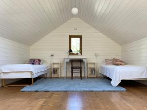 una camera da letto con 2 letti e una scrivania in mansarda di The Green House a Stoccolma