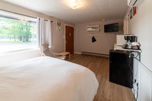 a bedroom with a white bed and a window at Star Gate Motel in Indian River