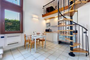a kitchen with a table and a spiral staircase at In riva al mare in Cagliari