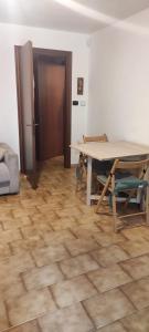 uma sala de jantar com uma mesa e piso em madeira em Appartamento IL QUADRIFOGLIO em Saint-Oyen