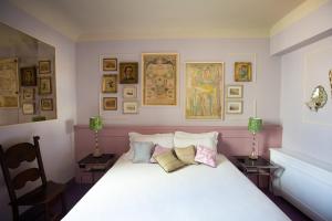 a bedroom with a white bed with pictures on the wall at Stella d'Italia in Florence