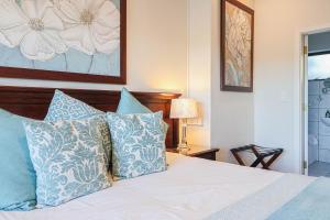sypialnia z łóżkiem z niebiesko-białymi poduszkami w obiekcie Amber Guest Lodge w mieście Knysna