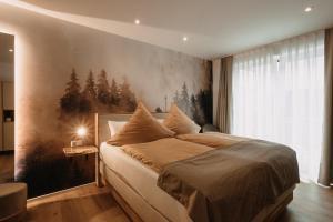Boutique Hotel Haus Marie في Gerabronn: غرفة نوم بسرير كبير عليها لوحة على الحائط