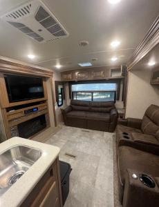 an rv living room with a couch and a tv at Sunrise Hideaway in Crystal River