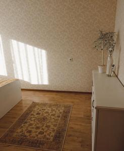 a kitchen with a rug on the floor and a window at Dviejų kambarių butas in Tauragė