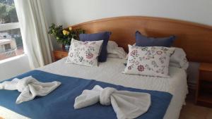 a bed with towels and pillows on it at Villa Margarita in Cala Millor