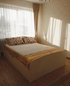 a bed sitting in a bedroom with a window at Dviejų kambarių butas in Tauragė