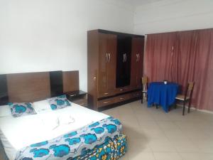1 dormitorio con 1 cama, mesa azul y sillas en CHIP RESIDENCIAL en Luanda
