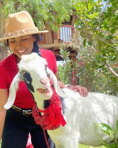 a woman in a hat holding a goat at Voyaca Hotel Alfareria in Villa de Leyva