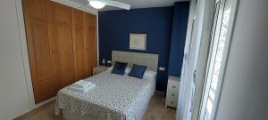 a blue bedroom with a bed with blue walls at Apartamento La Porteña, 200 ms de playa Victoria in Cádiz