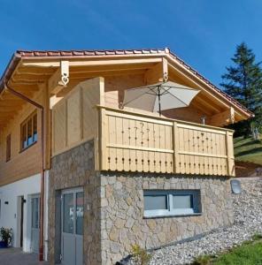 a house with a balcony with an umbrella on it at Herzbluad Chalet in Wallgau
