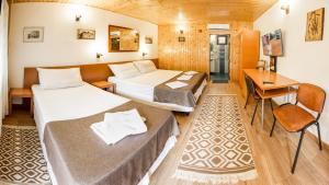 um quarto de hotel com duas camas e uma secretária em Pensiunea Casa Verde Bucuresti em Bucareste