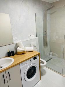 a bathroom with a washing machine and a toilet at SNC Residence V in Şelimbăr