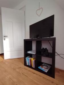 a black book shelf with a flat screen tv on it at Meer-Harmonie in Kiel