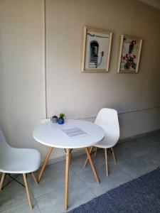 uma mesa branca e duas cadeiras brancas num quarto em Annies Overnight em Vanderbijlpark